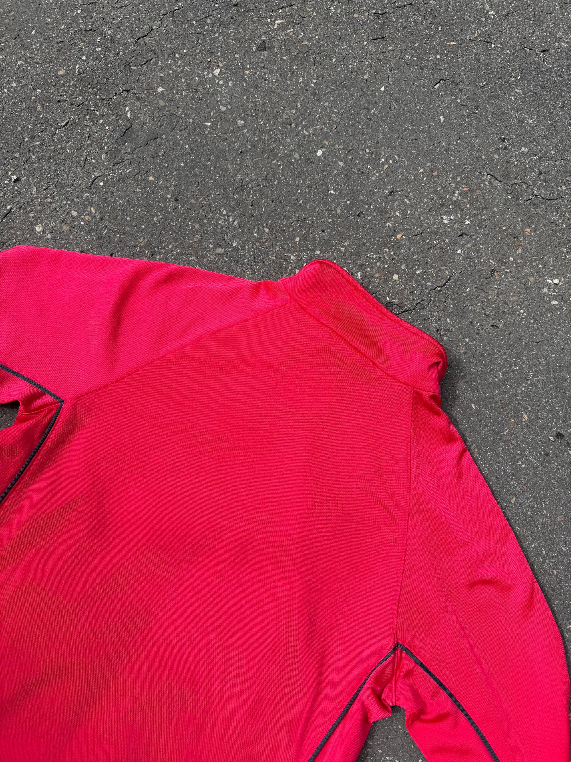 Eine Pinke Trackjacke von Adidas mit weißen Streifen auf den Ärmeln