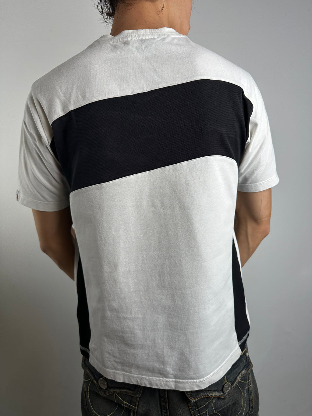 Tragebild von hinten von schwarz weißem Nike Tshirt  vor grauer Wand