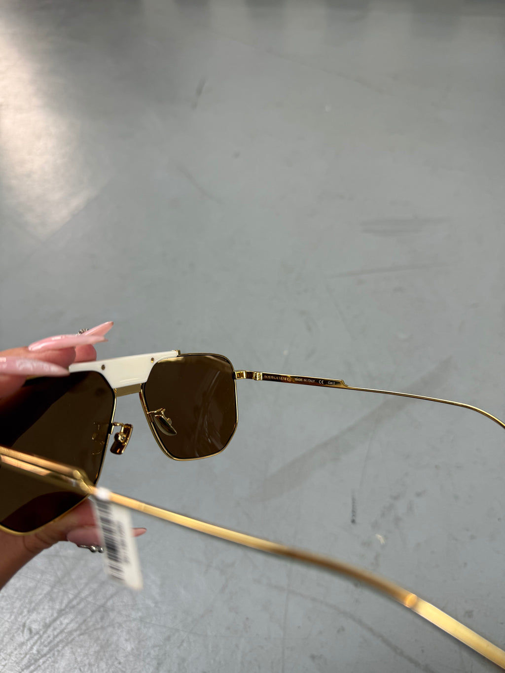 Eine weiß goldene Sonnenbrille mit großen Gläsern von Bottega veneta 