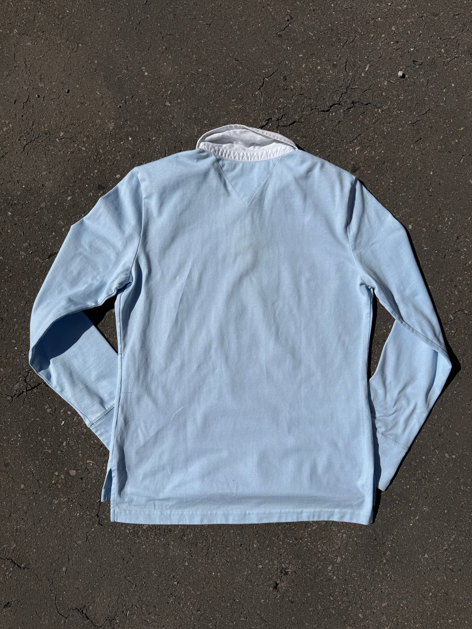 Ein babyblaues langärmliges Polo mit weißem Kragen und Hilfiger in Silber auf der Brust geschrieben 