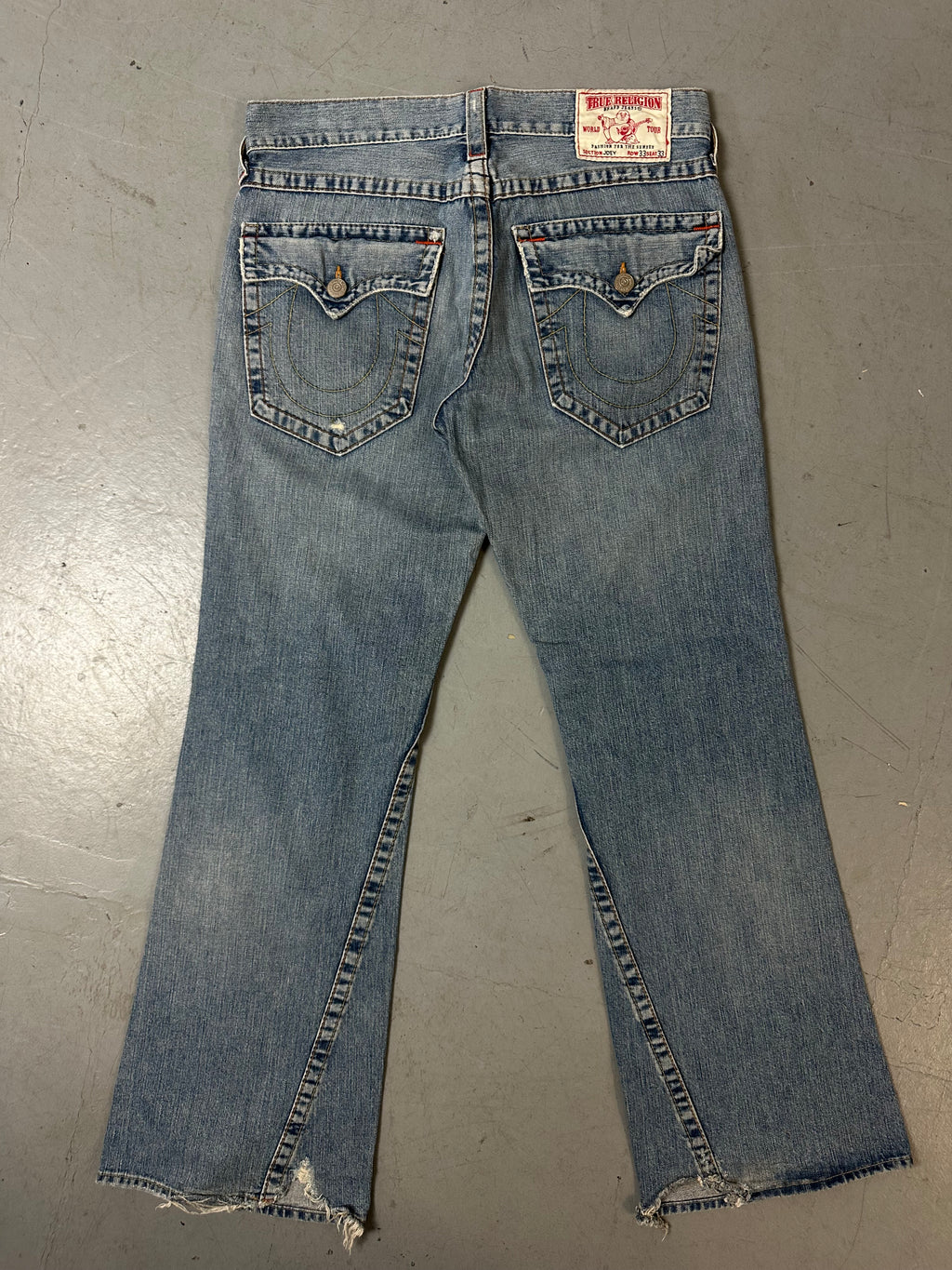 Eine blau-graue baggy True Religion Jeans mit weißen Hufeisen Stitching