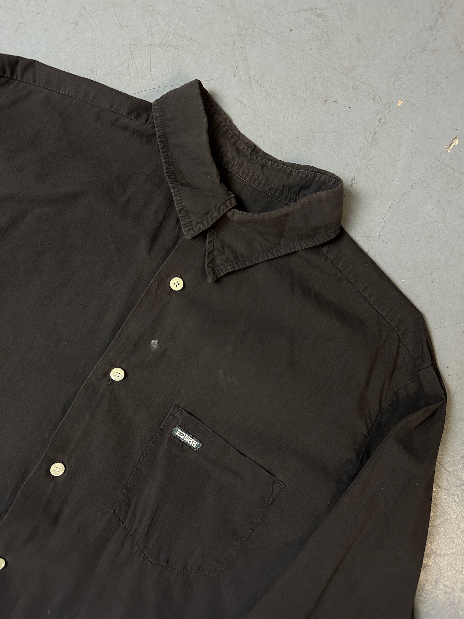 Detailliertes produktbild von grauem Diesel Hemd auf Boden