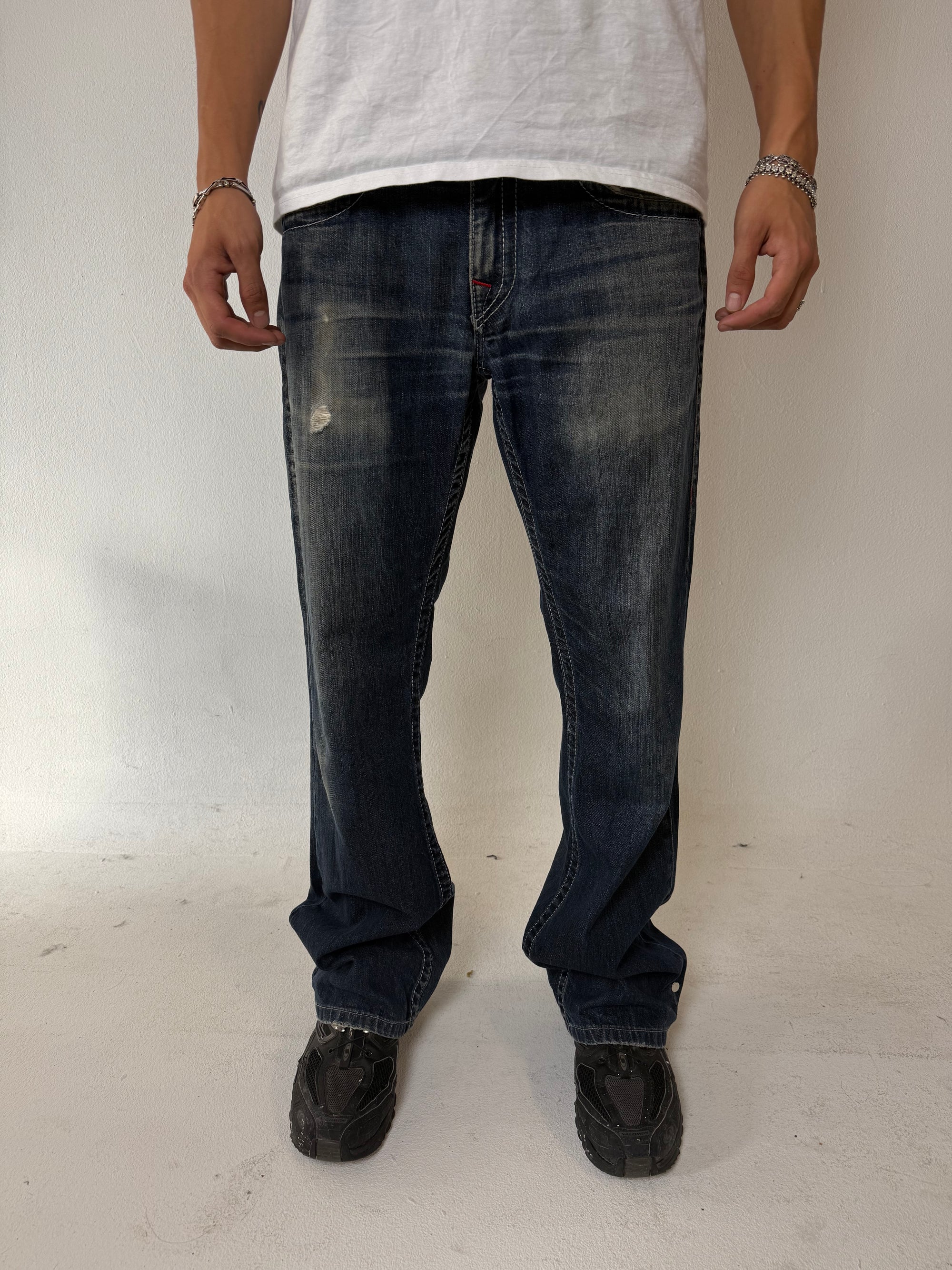 Eine dunkelblaue baggy True Religion mit roten Nähten und roten Hufeisen auf den Backpockets