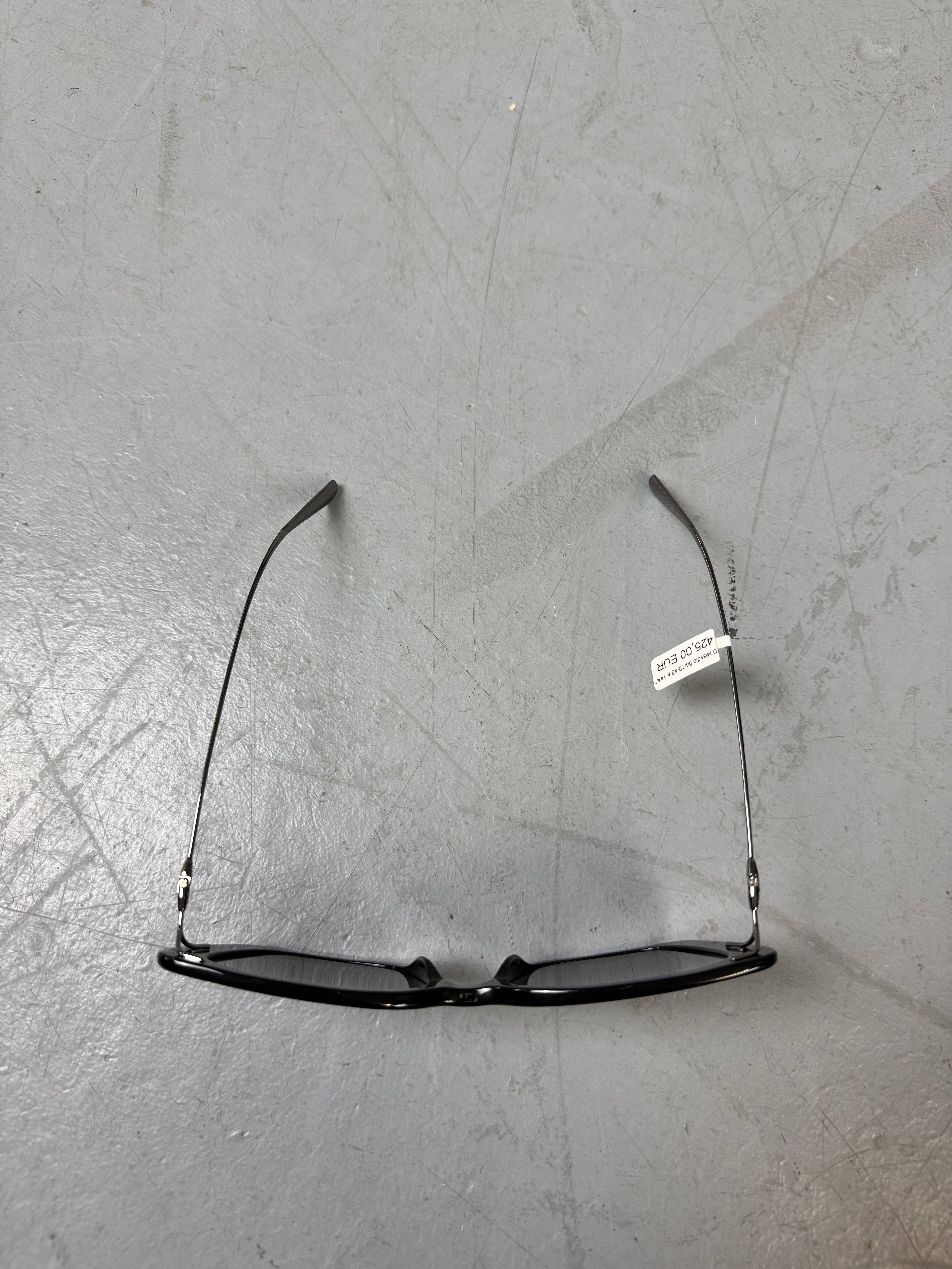 Eine schwarze Sonnenbrille von Dior mit dünnen Bügeln und die Gläser im cateye look 