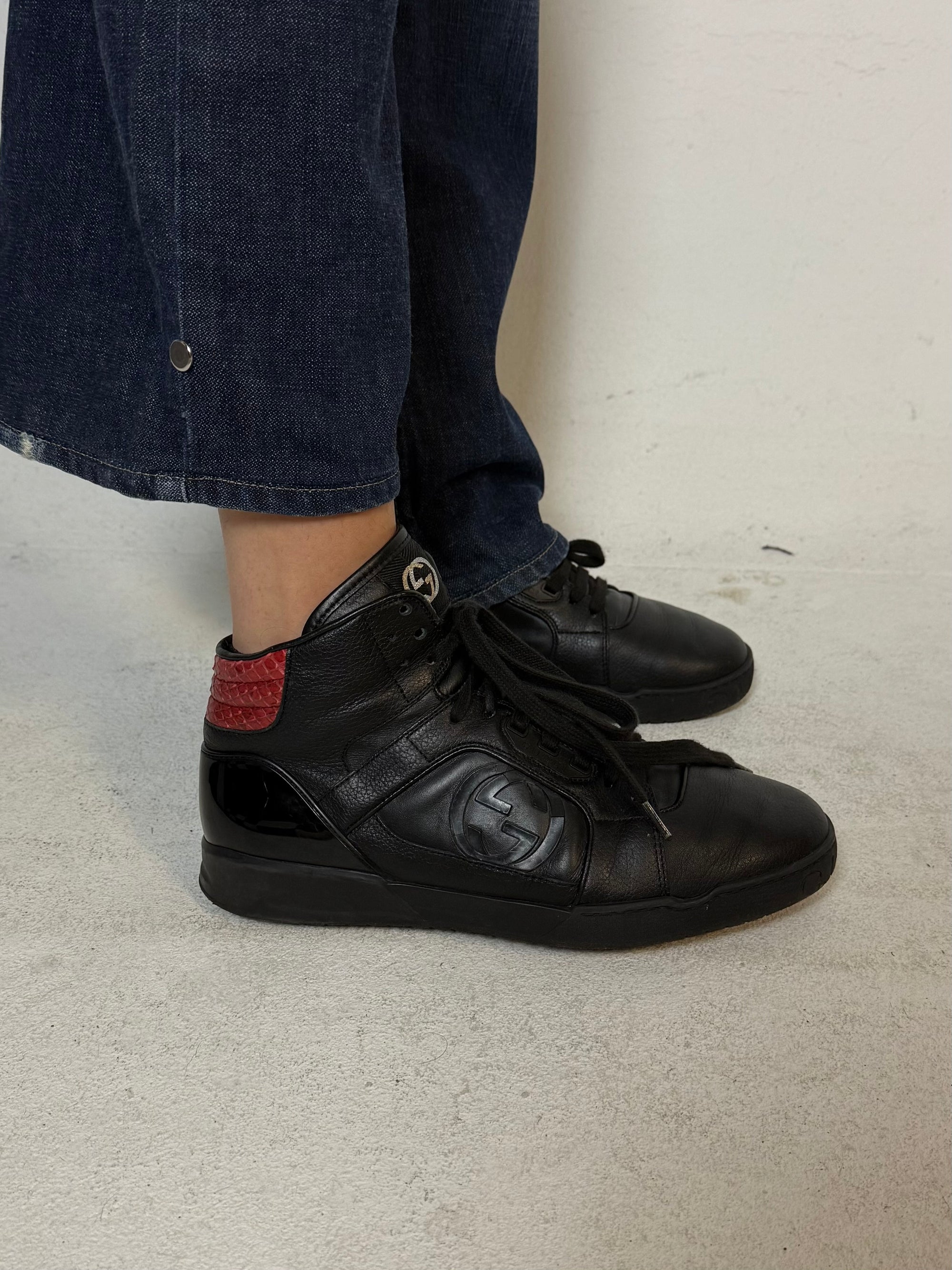 Schwarze gucci sneaker mit roten details hinten und roter sohle