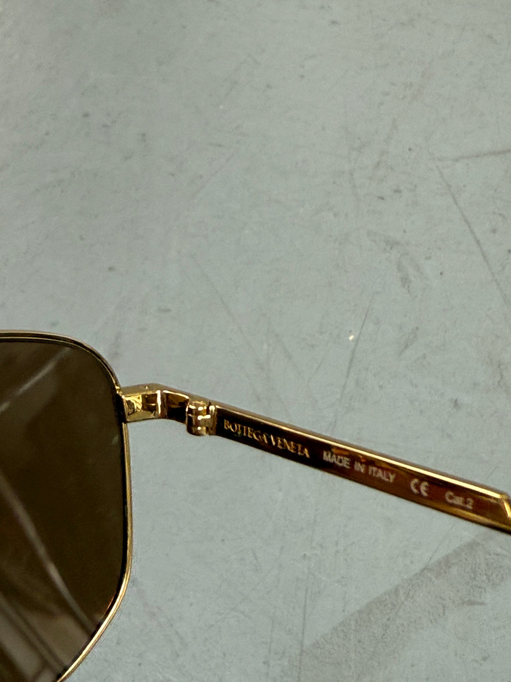 Eine weiß goldene Sonnenbrille mit großen Gläsern von Bottega veneta 
