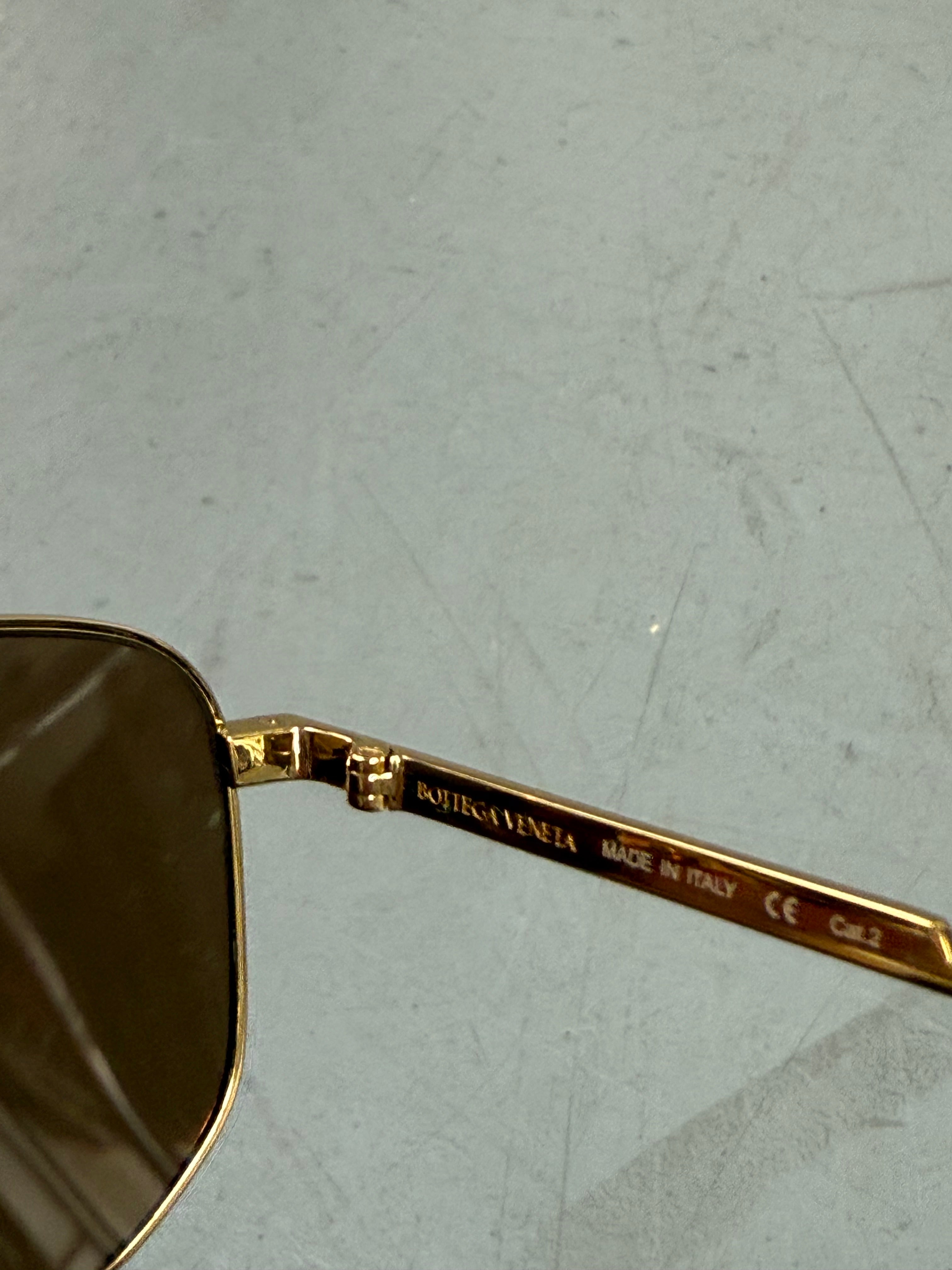 Eine weiß goldene Sonnenbrille mit großen Gläsern von Bottega veneta 