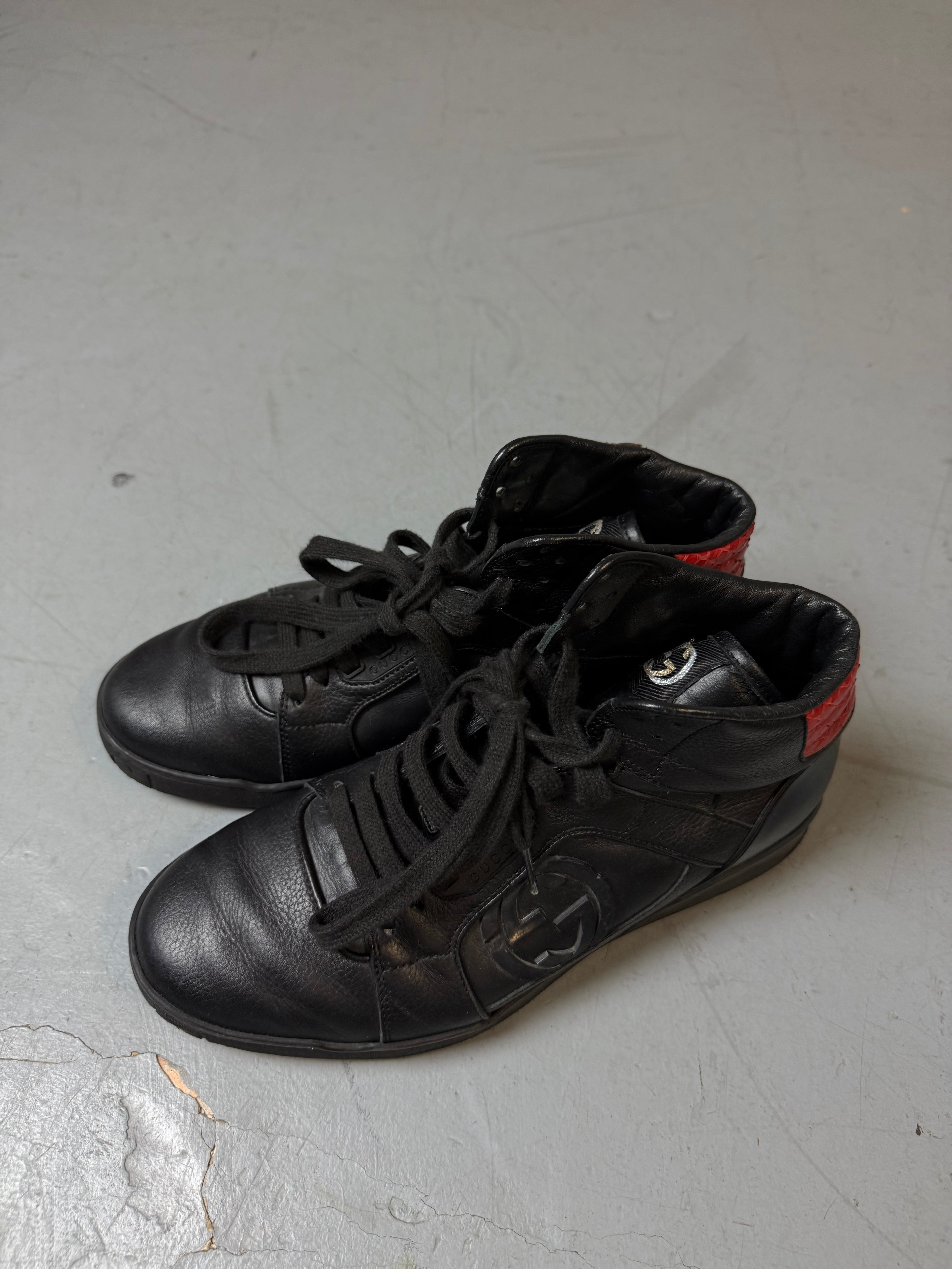 Schwarze gucci sneaker mit roten details hinten und roter sohle 