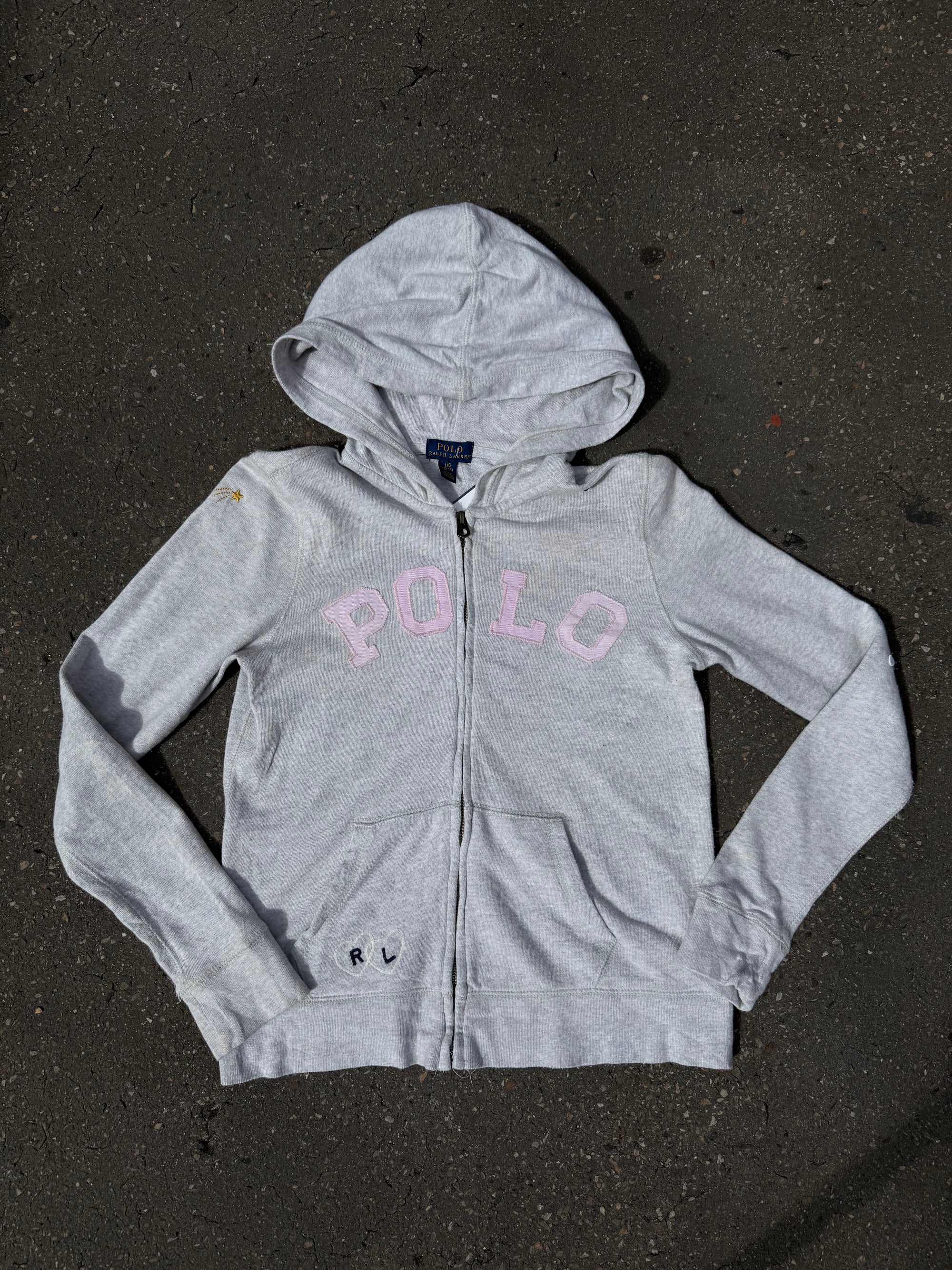 Ein grauer Zip Up Hoodie von Polo Ralph Lauren mit rosa Polo Aufdruck auf der Brust und kleinen patches überall verteilt in XS