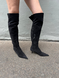 Zu sehen sind kniehohe schwarze Stiefel mit dünnen Absätzen von Fendi in Größe 38,5 von der Seite vor einem grauen Hintergrund.