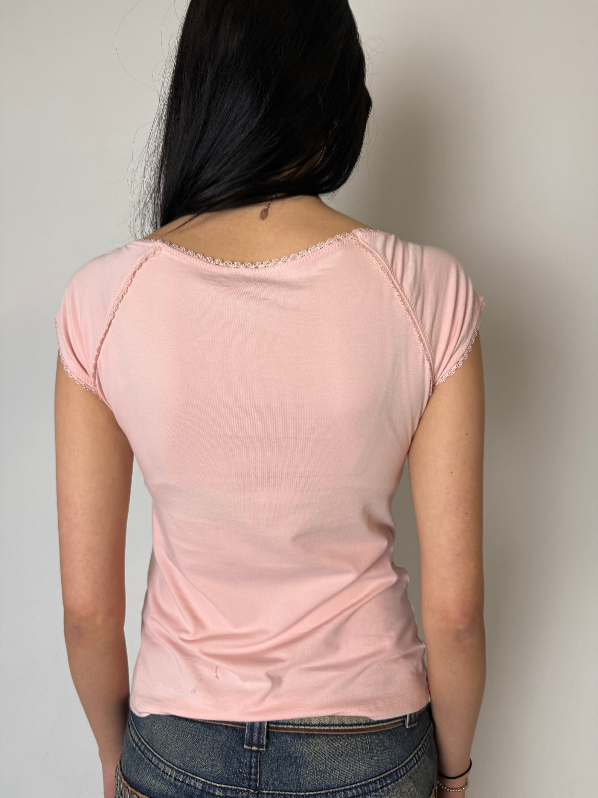 Ein rosa tshirt von Denny Rose mit schwarzem Logo auf der Brust und lace am Kragen und den Ärmeln 