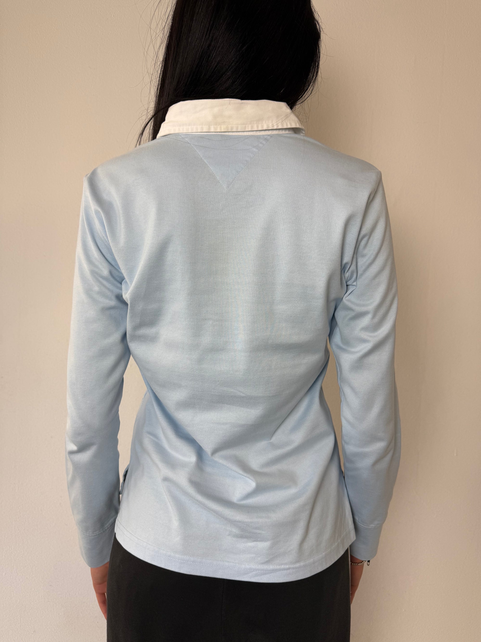Ein babyblaues langärmliges Polo mit weißem Kragen und Hilfiger in Silber auf der Brust geschrieben 