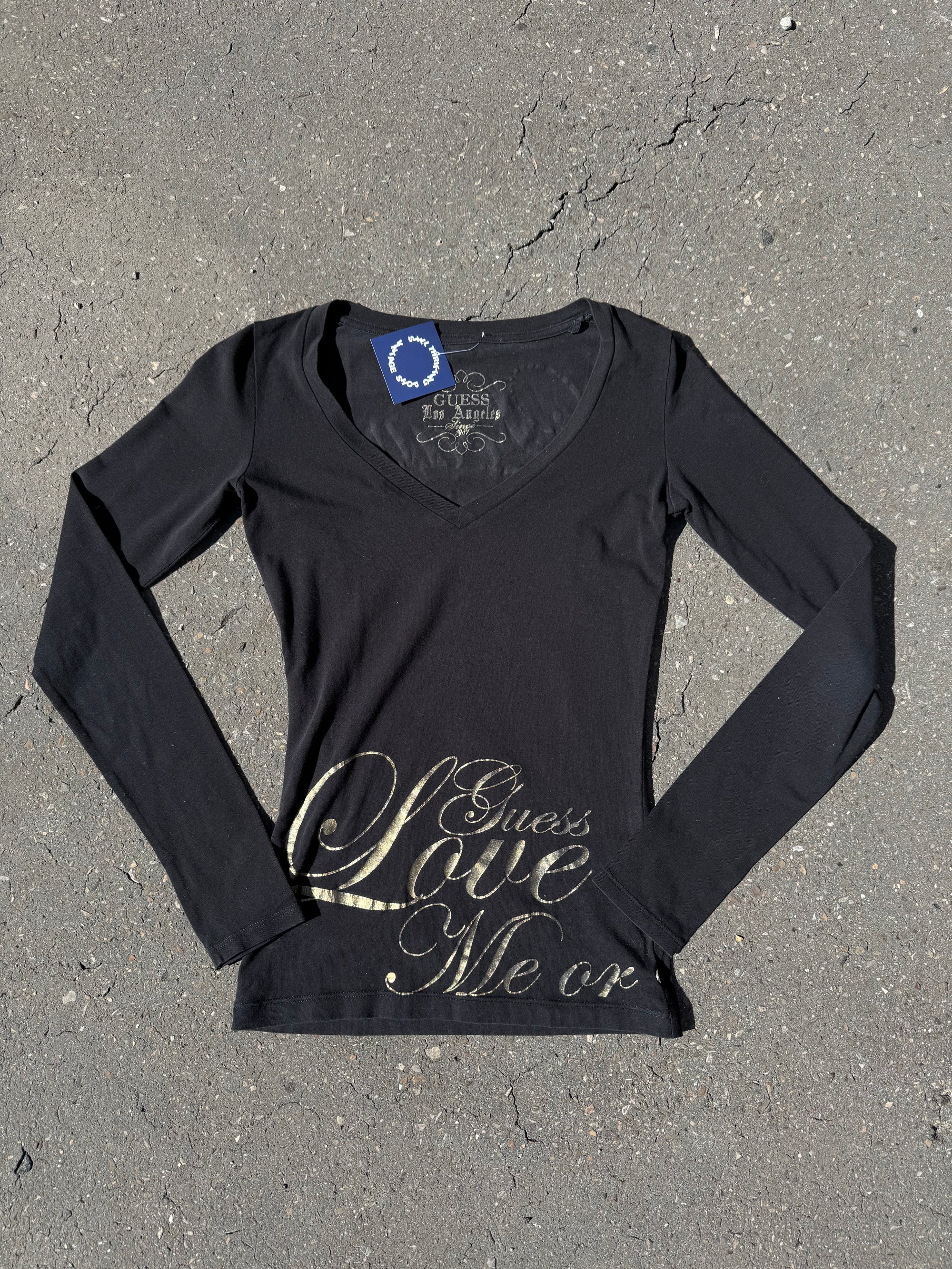 Ein schwarzes Longsleeve von Guess mit goldenem Schriftzug auf der Vorderseite und Rückseite Slim Fit