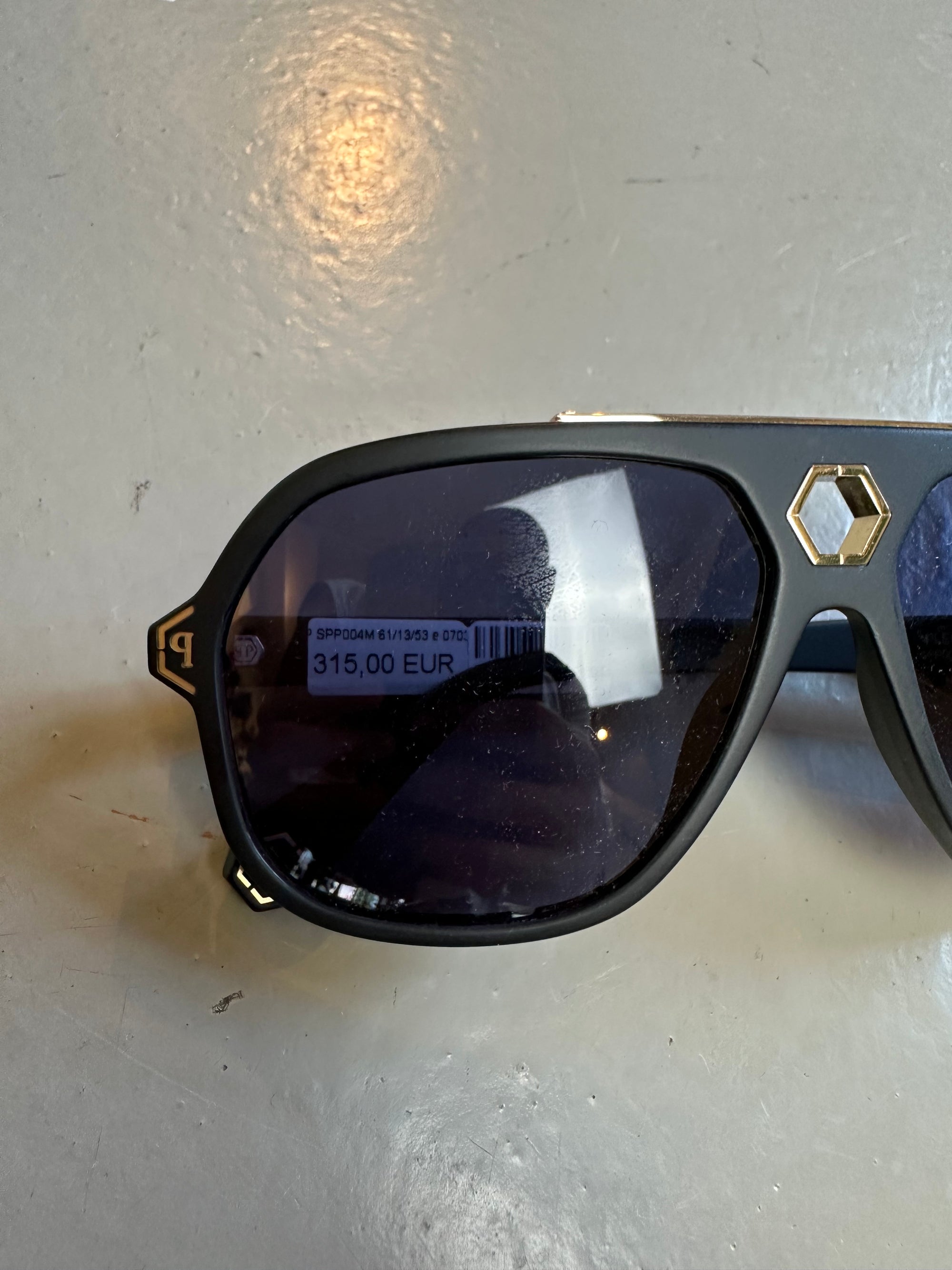 Zu sehen ist ein Detailbild von den Gläsern einer Philipp Plein Sunglasses von vorne vor einem grauen Hintergrund.