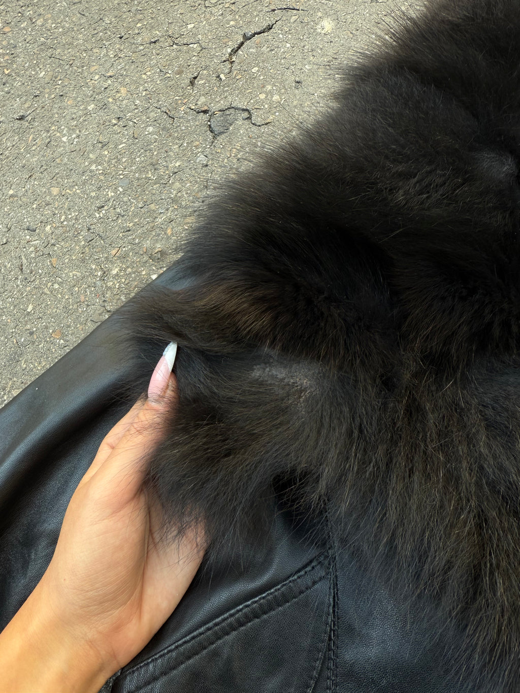 Eine schwarze Lederjacke mit Faux Fur am Kragen und an den Ärmeln