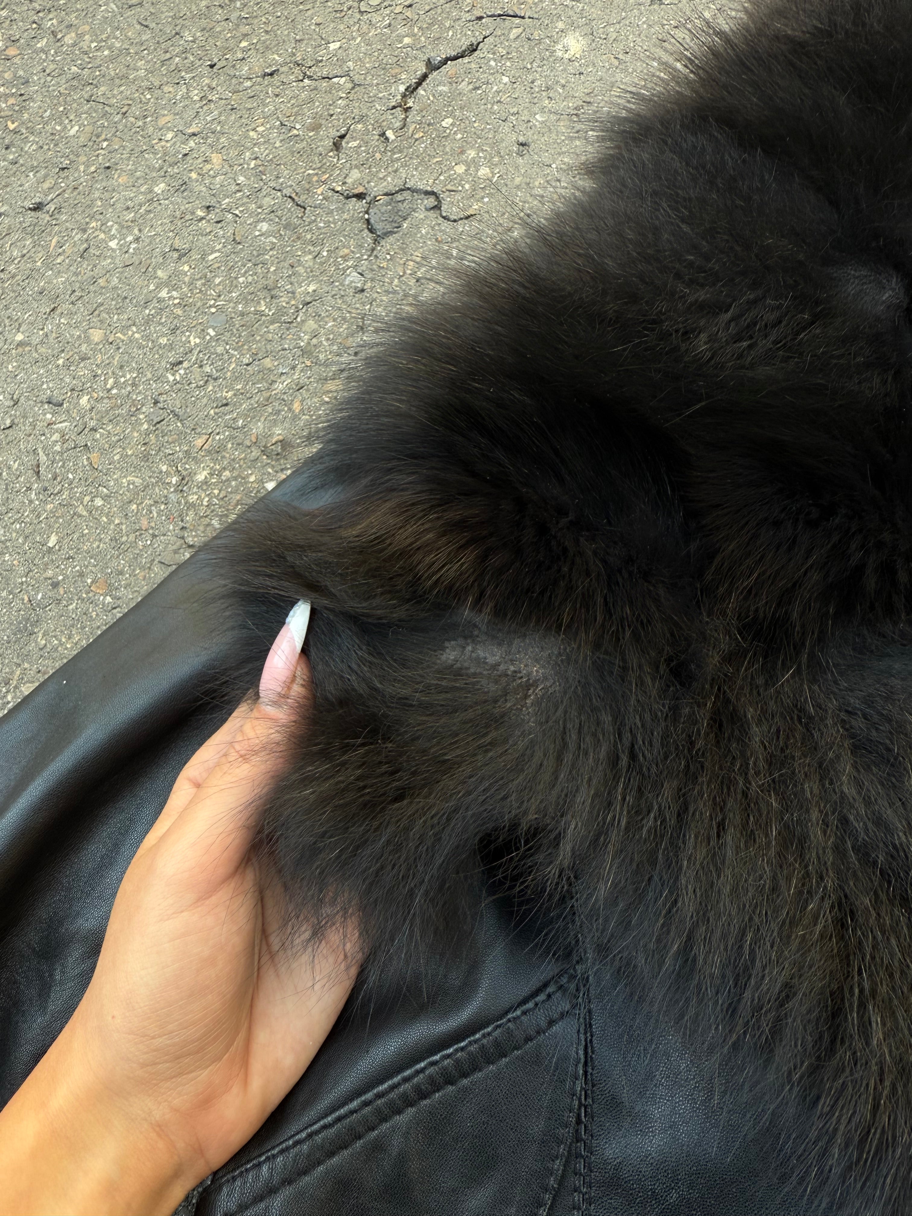 Eine schwarze Lederjacke mit Faux Fur am Kragen und an den Ärmeln