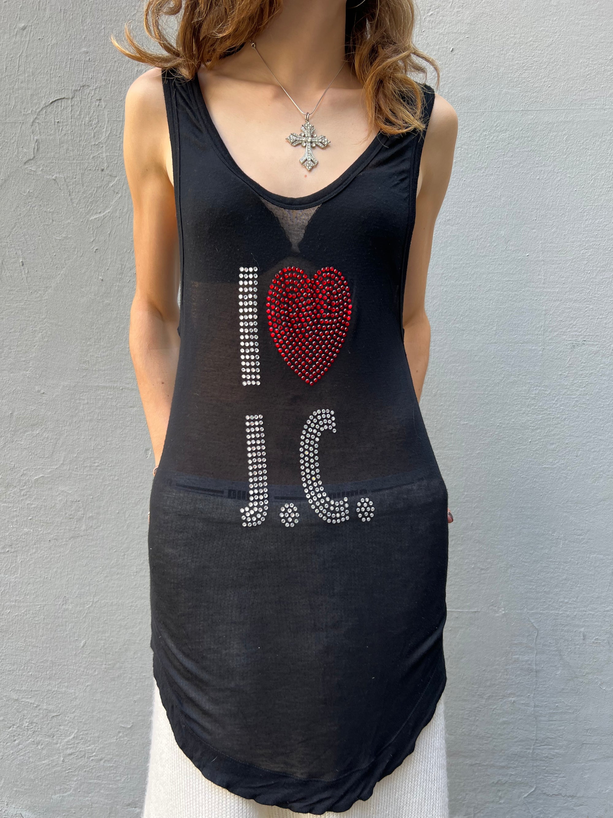 Langes schwarzes Top von Roberto Cavalli, Aufschrift “I love J.C” in glitzersteinen, tragebild vor grauem Hintergrund, frontal.
