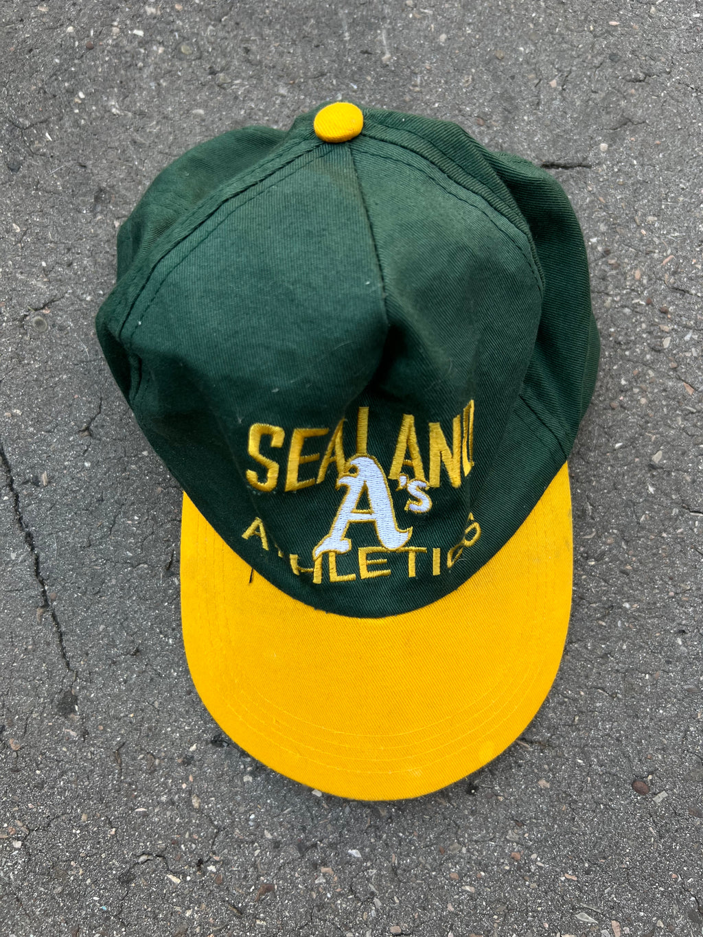 Eine grüne Cap mit gelben Sealand Schriftzug und gelben Schirm