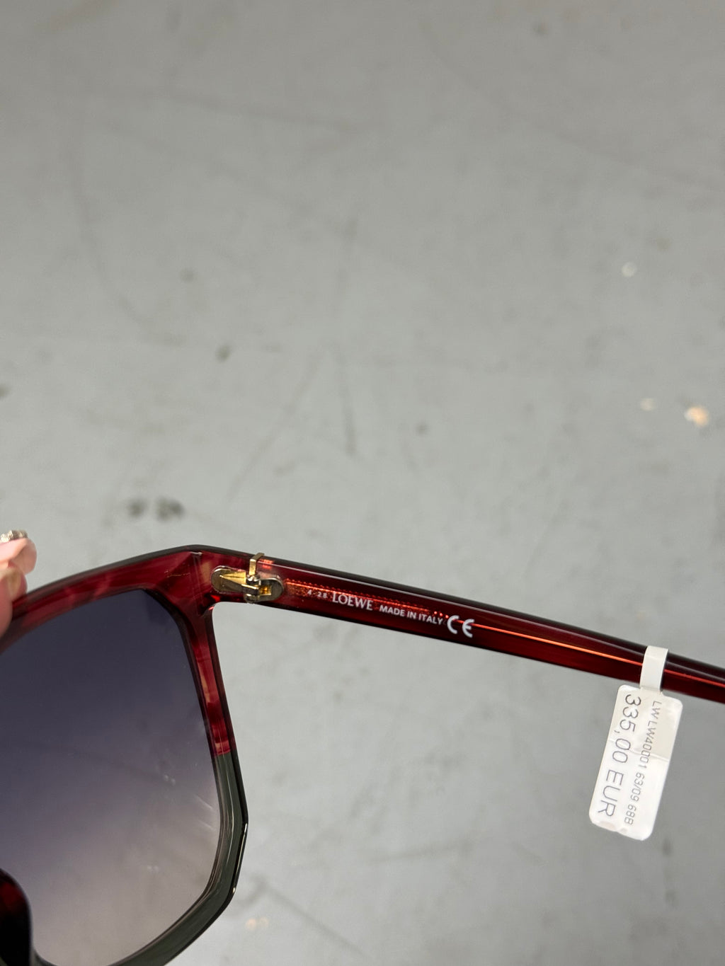 Eine Loewe Sonnenbrille mit großen dunklen Gläsern und rotem Gestell 