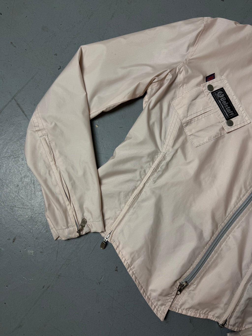 Vintage Belstaff Light Pink Jacket Getragen mit schrägem zipper vor weißer Wand