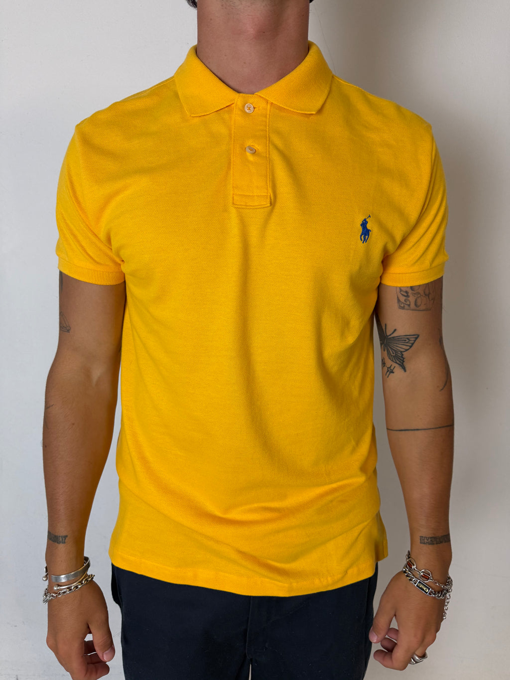 Ein gelbes Polo von Ralph Lauren mit blauem Reiter auf der Brust in L