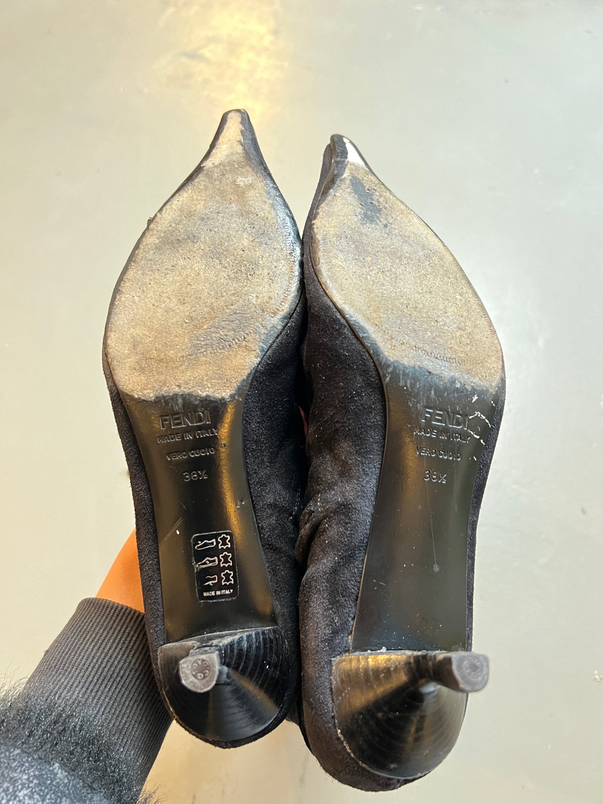 Zu sehen sind die Sohlen von kniehohe schwarze Stiefel mit dünnen Absätzen von Fendi in Größe 38,5  vor einem grauen Hintergrund.