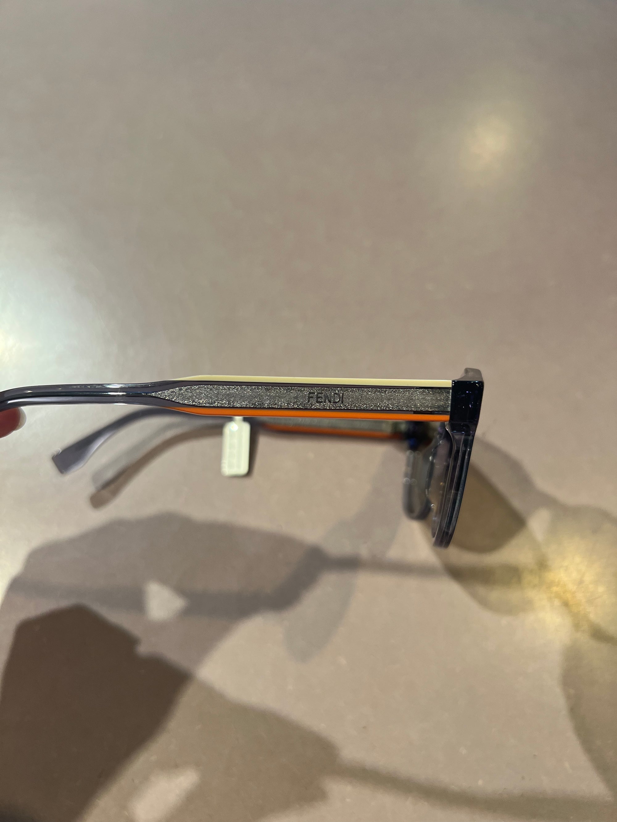 Auf dem Bild ist ein Produktbild der Fendi Roma Sonnenbrille von der Seite vor Grauen Hintergrund zu sehen.