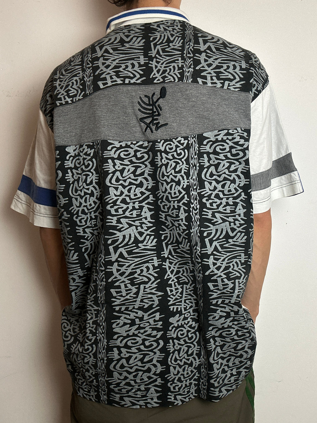 Ein Polo Shirt von Lotto in weiß mit blau schwarzen Ärmeln vintage Y2K 