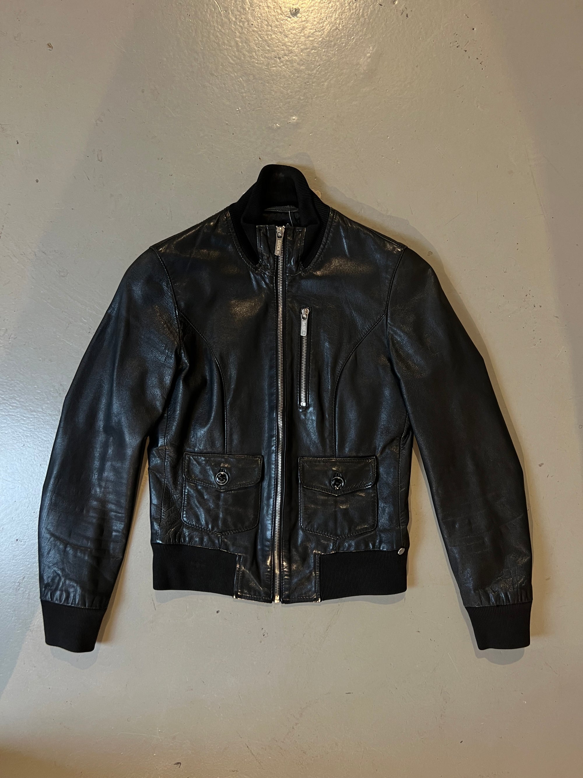 Produktbild von schwarzer Lederjacke vorne Auf grauem Boden 