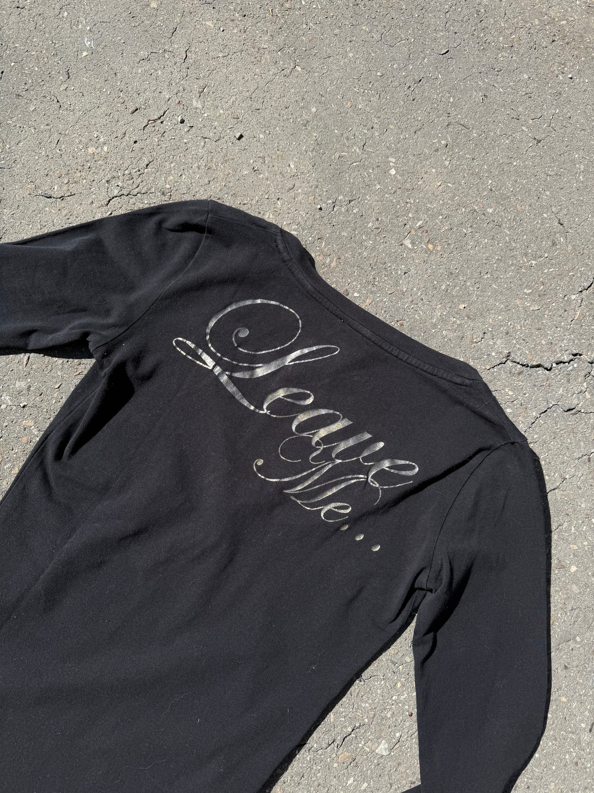 Ein schwarzes Longsleeve von Guess mit goldenem Schriftzug auf der Vorderseite und Rückseite Slim Fit