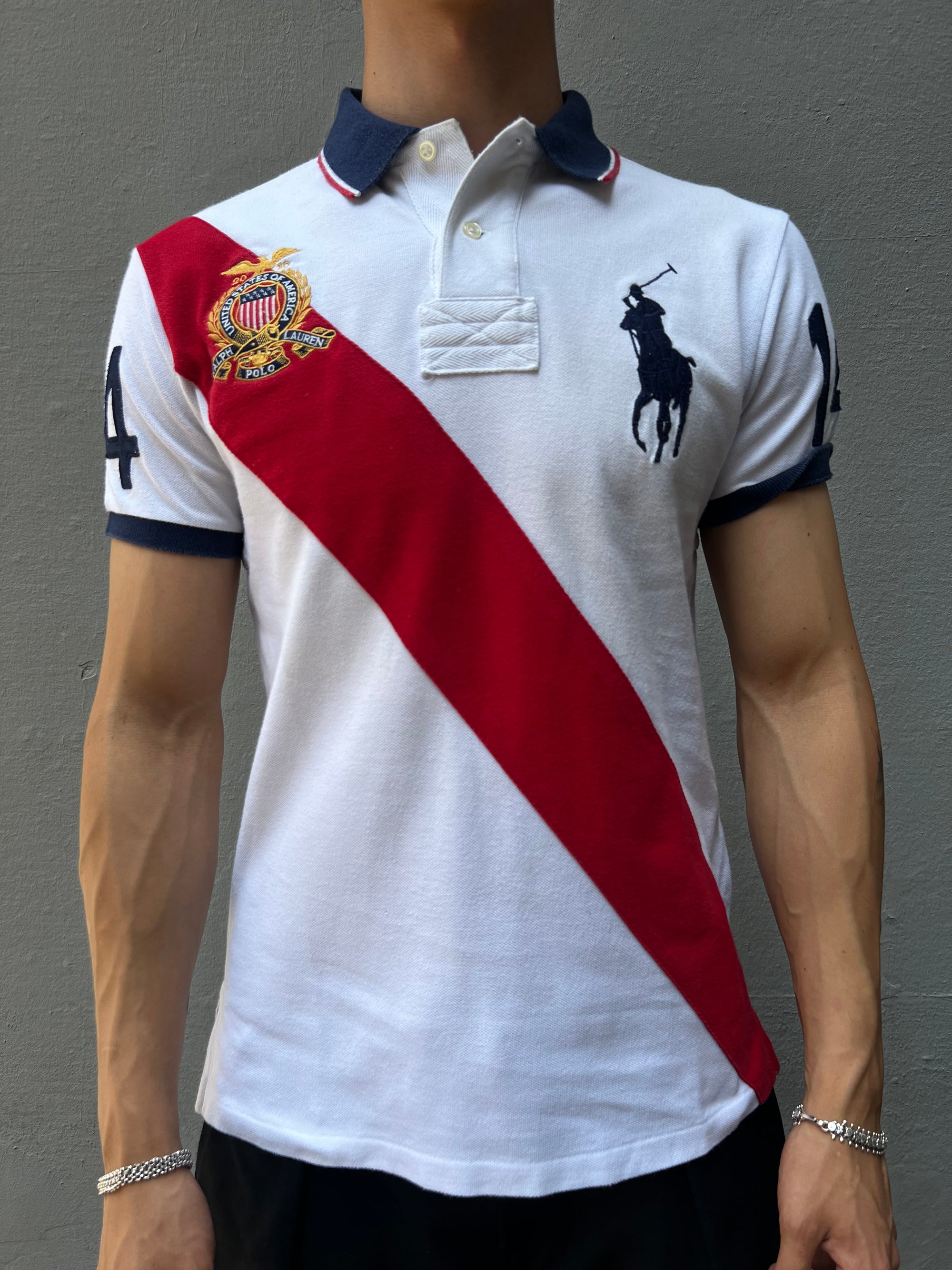 Ein weißes Ralph Lauren Polo mit großem Reiter auf der Brust und roter Strefien in M 