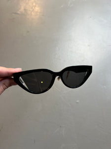 Produktbild von schwarzer Fendi Cat-Eye Sonnenbrille vor grauem Hintergrund.