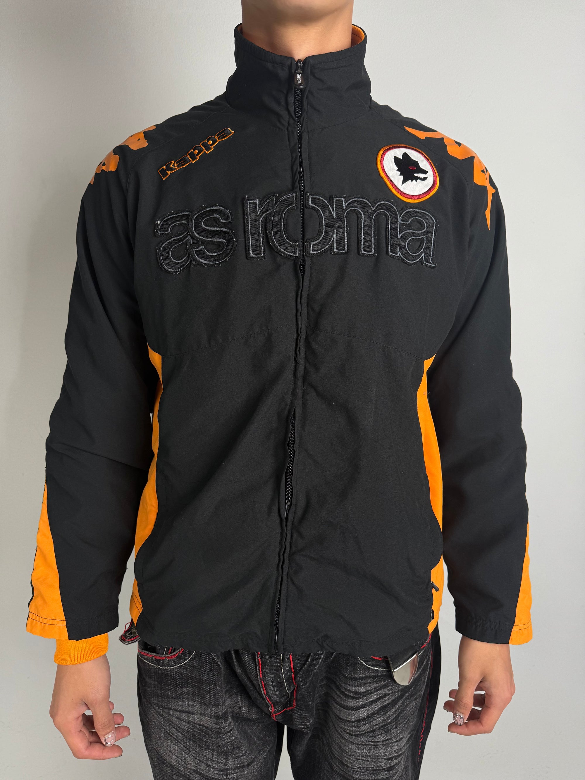 Eine schwarz orange Track Jacke von kappa von dem Fußballverein as roma 