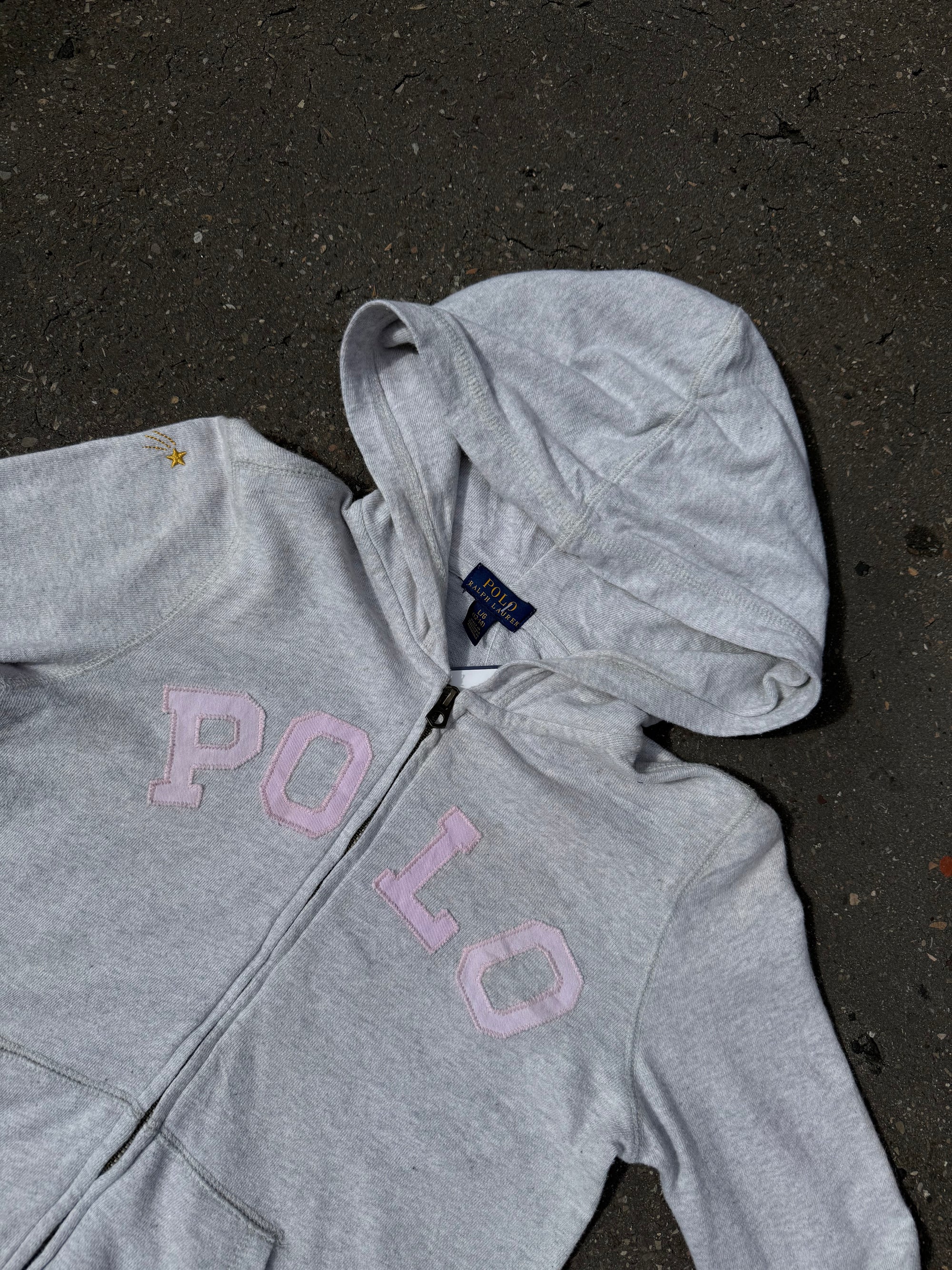 Ein grauer Zip Up Hoodie von Polo Ralph Lauren mit rosa Polo Aufdruck auf der Brust und kleinen patches überall verteilt in XS