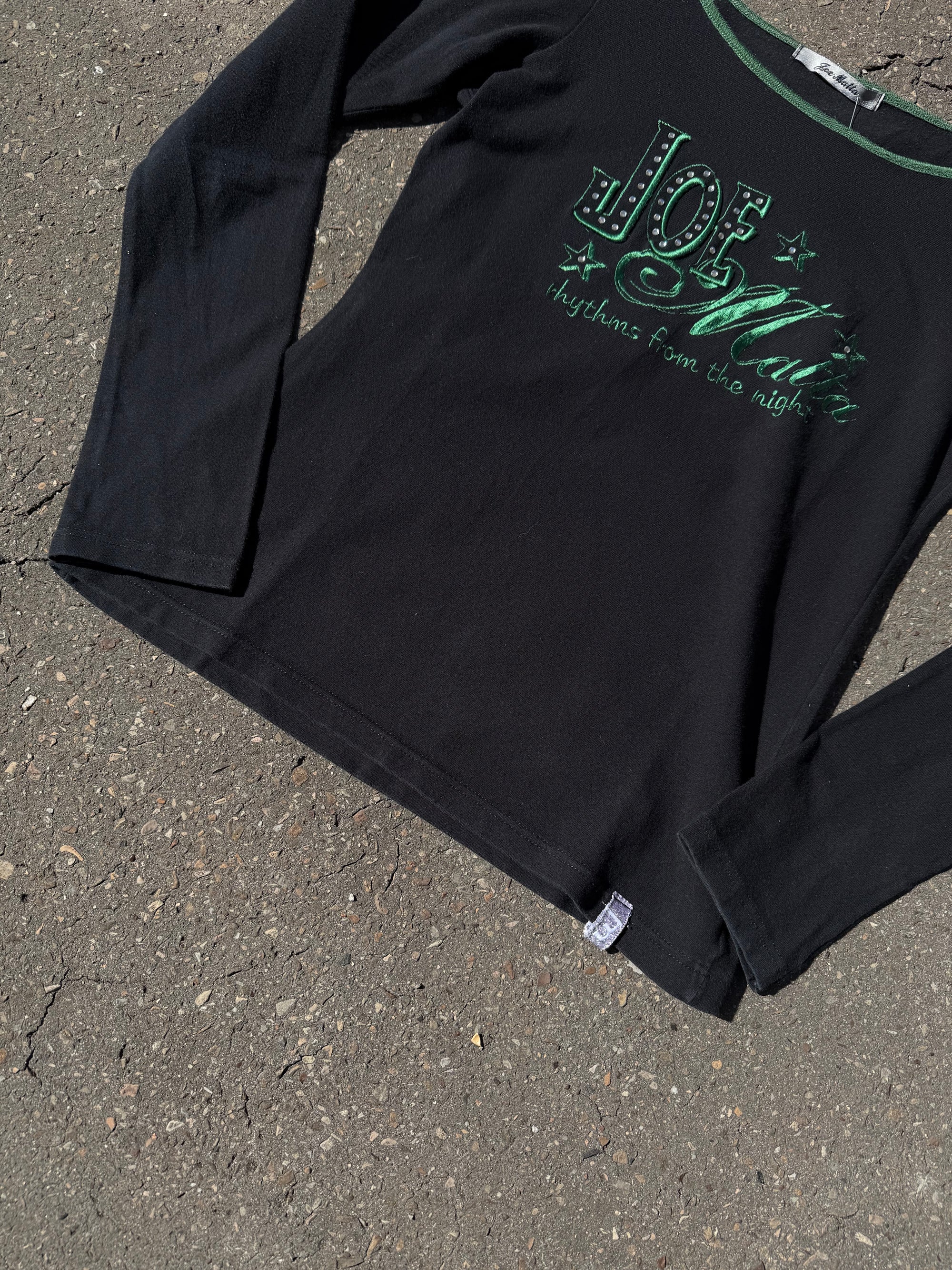 Ein schwarzes longsleeve mit einem grünen Joe Matta Aufschrift auf der Brust