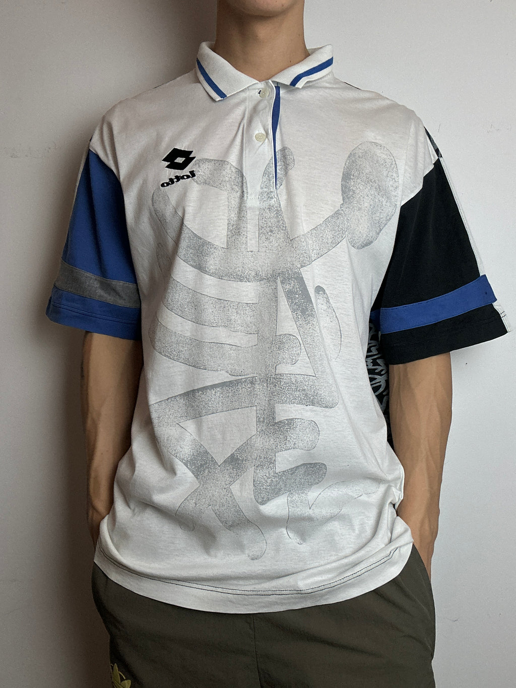 Ein Polo Shirt von Lotto in weiß mit blau schwarzen Ärmeln vintage Y2K 