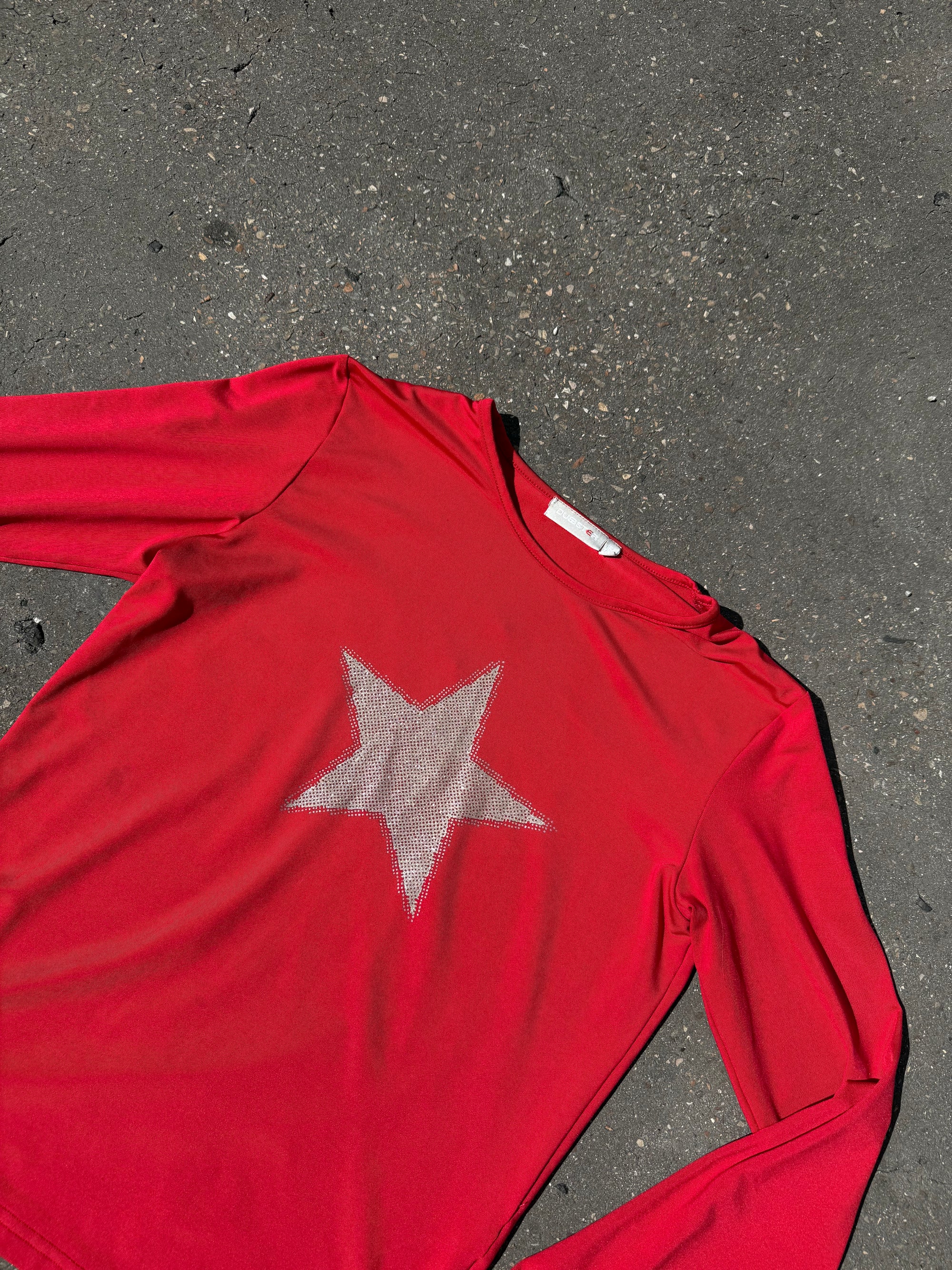 Ein rotes longsleeve mit einem Stern in der Mitte 
