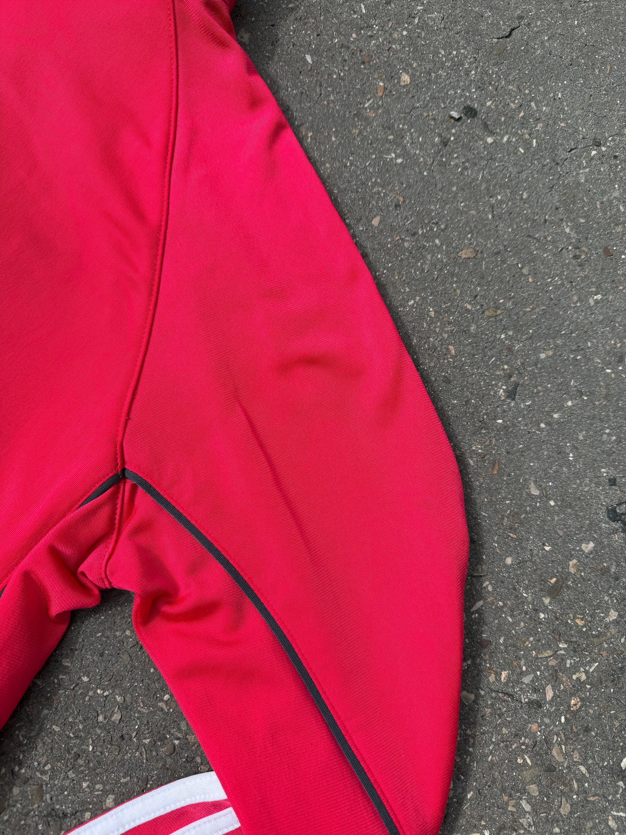 Eine Pinke Trackjacke von Adidas mit weißen Streifen auf den Ärmeln