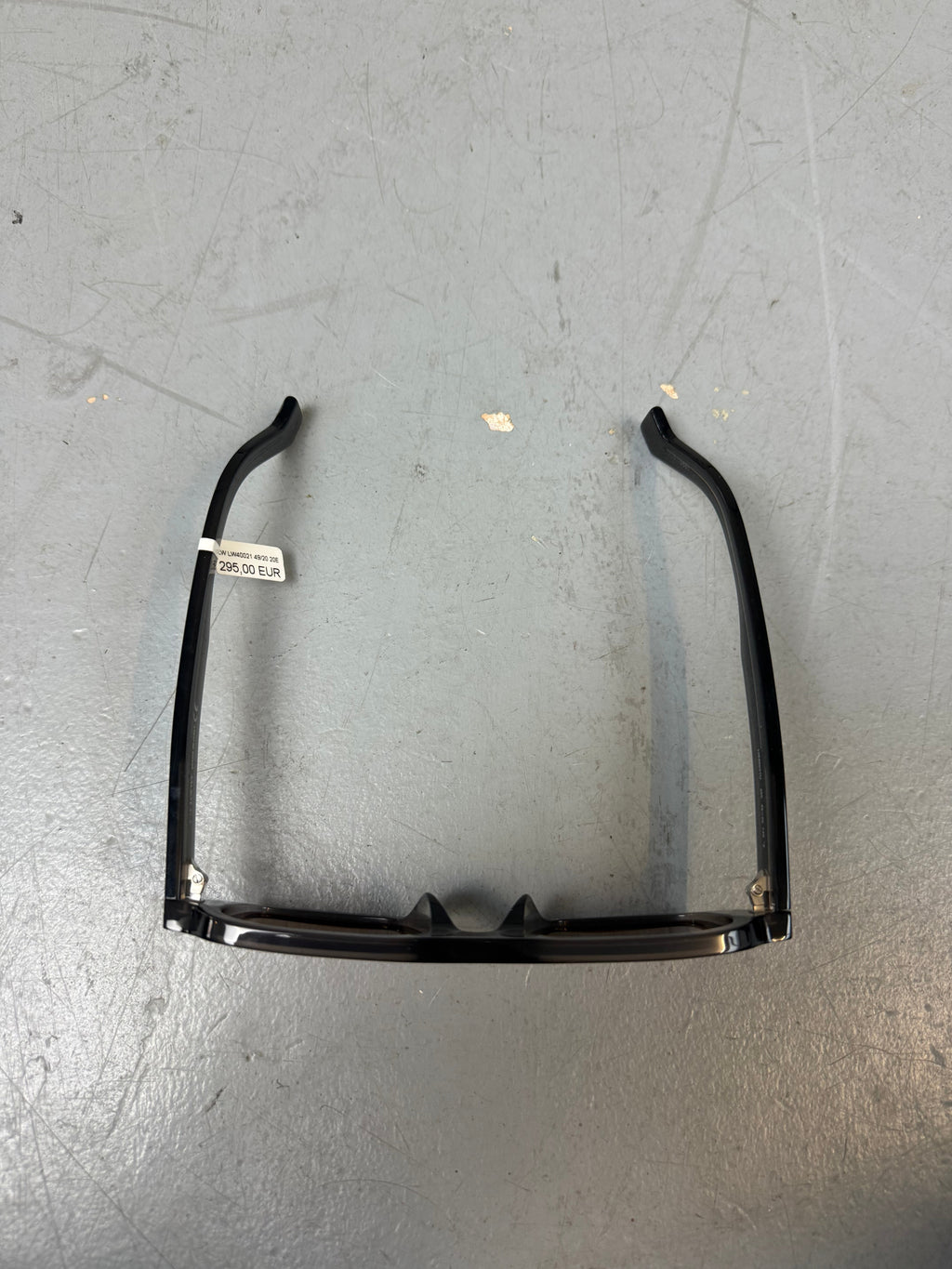 Eine rechteckige Sonnenbrille mit orangen Gläsern und grauem Gestell von Loewe 