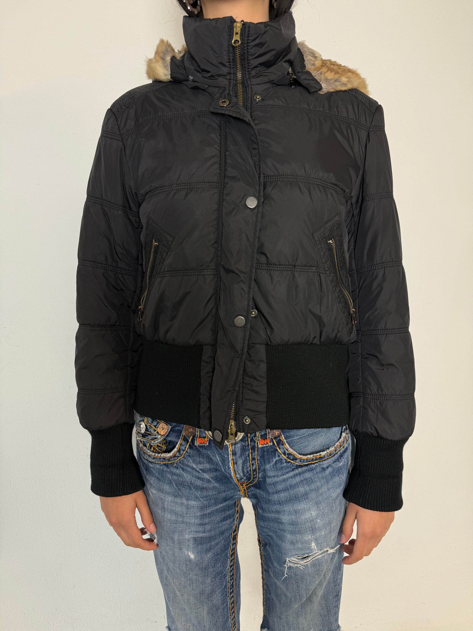 Eine schwarze cropped Puffer Jacke im Y2K Stil mit faux fur Kaputze 