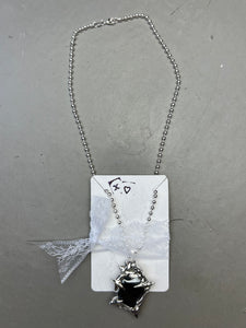 Produktbild von einer silbernen Halskette mit einem schwarzen Hematite Anhänger von Xullery vor einem grauen Hintergrund.