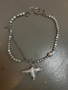 Produktbild von Xullery Cross Grey Pearl Necklace auf grauem Boden.