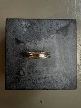 Laden Sie das Bild in den Galerie-Viewer, Produktbild von der Seite von Tragebild vom Ringfinger von Ringsbyclausen Ring „Krater 3“ vor grauer Wand vor Beton Boden 