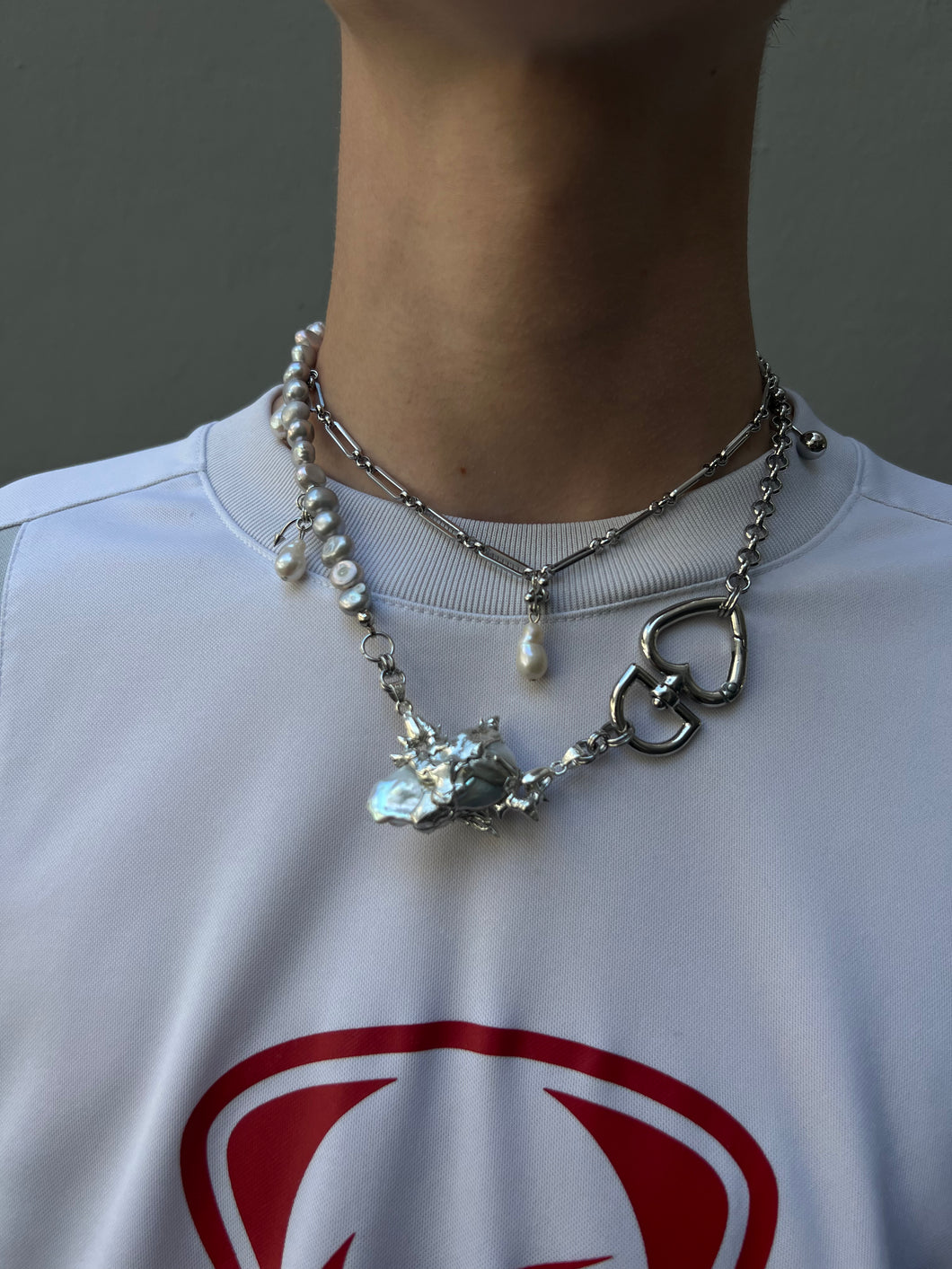 Tragebild von vorne von Xullery Grey Pearl Necklace vor einem grauen Hintergrund