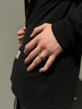 Laden Sie das Bild in den Galerie-Viewer, Tragebild vom Ringfinger von Ringsbyclausen Ring „Krater 3“ vor grauer Wand