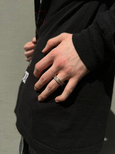 Tragebild vom Ringfinger von Ringsbyclausen Ring „Krater 3“ vor grauer Wand