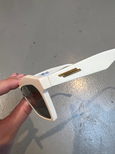 Laden Sie das Bild in den Galerie-Viewer, Produktbild von einer Bottega Veneta Sonnenbrille mit beigen Gehäuse vor einem grauen Hintergrund. 