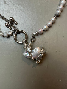 Xullery Grey Pearl Necklace DNA detailliertes Produktbild auf grauem Boden