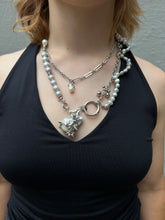 Laden Sie das Bild in den Galerie-Viewer, Xullery Grey Pearl Necklace DNA Tragebild von vorne vor grauer Betonwand