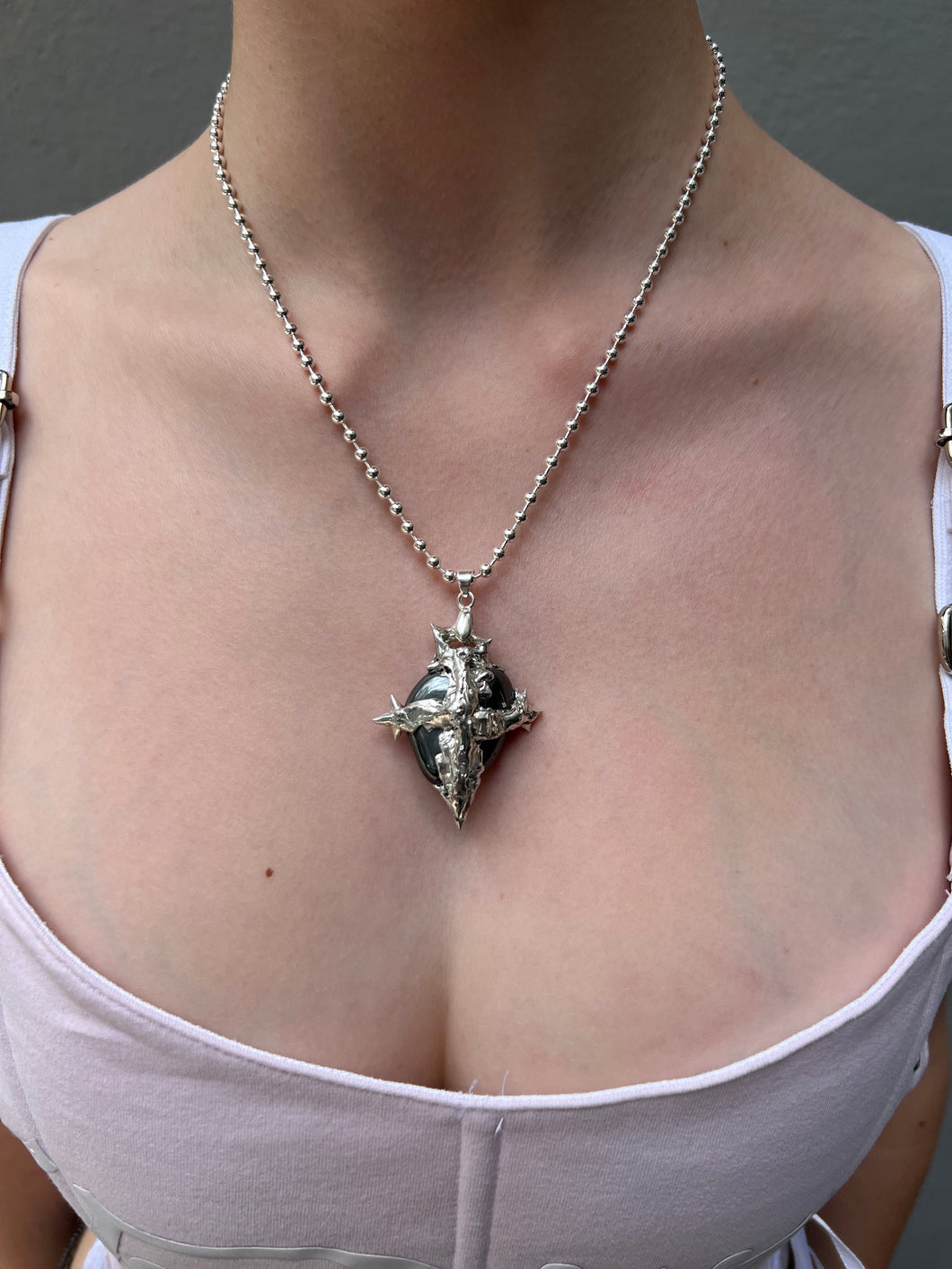 Tragebild von Xullery Hematite Necklace vor einem grauen Hintergrund.